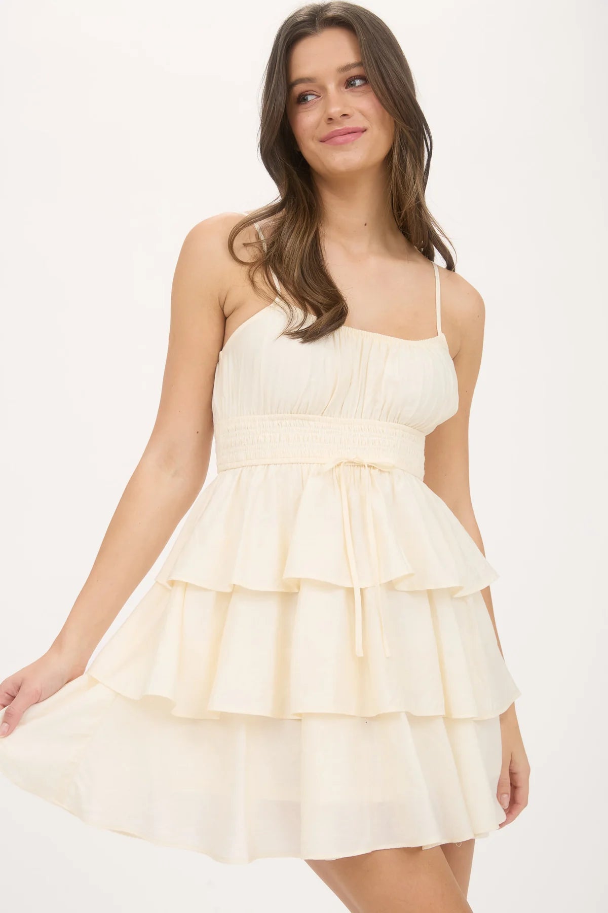 Model in a smocked waist, tiered ruffle mini dress with thin straps, styled for a chic summer vibe.