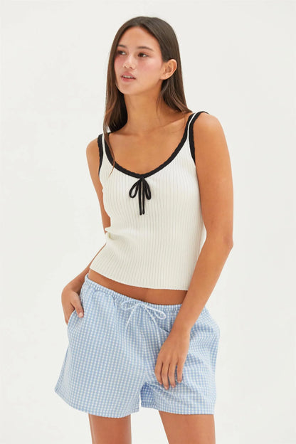 White ribbed tank with black trim and bow detail.